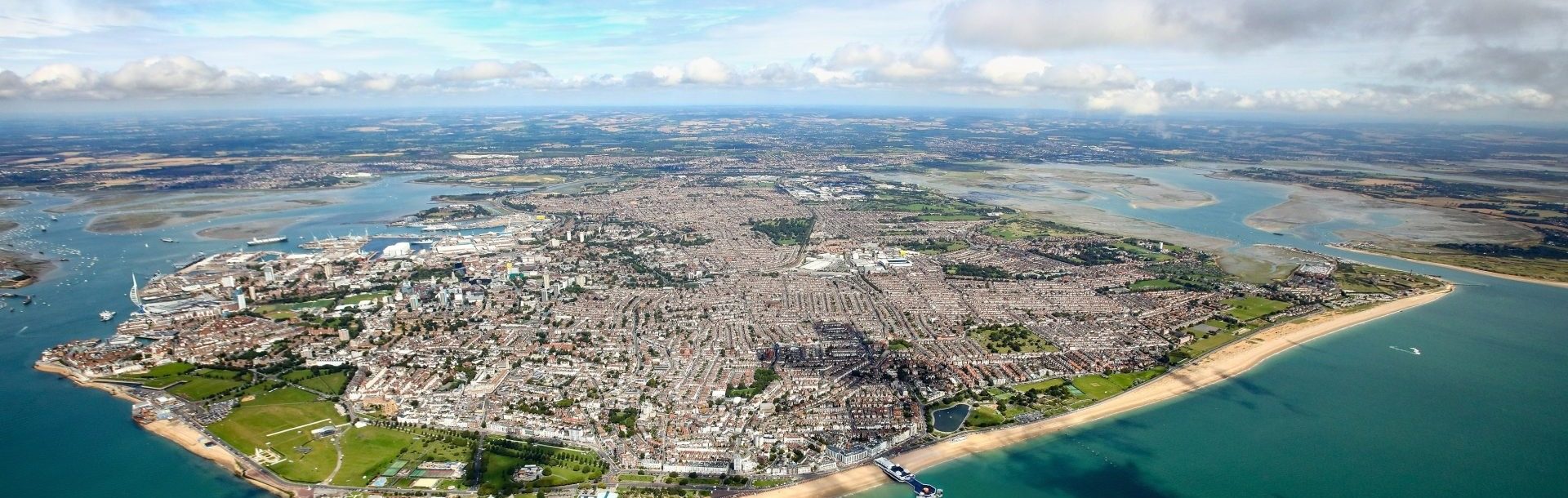 Aerial view of Portsmouth from the south, showing Portsea Island with the harbour and naval base to the west and Southsea seafront to the south.